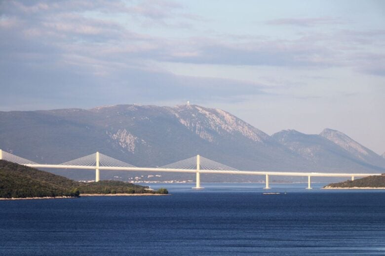 Breathtaking view of Pelješac Bridge with mountains and sea, captured in Neum, Bosnia and Herzegovina.