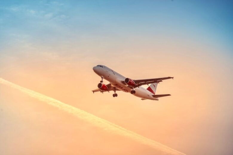 A commercial airplane flying through a beautiful sunset sky, showcasing aviation and travel beauty.