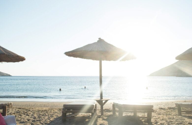 white patio umbrella near body of water