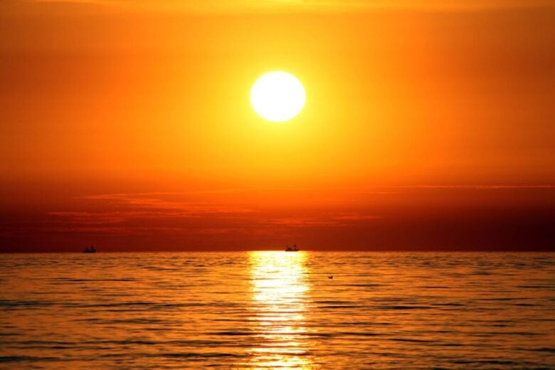 Vibrant sunset over the sea in Spain, reflecting warm hues on tranquil waters.