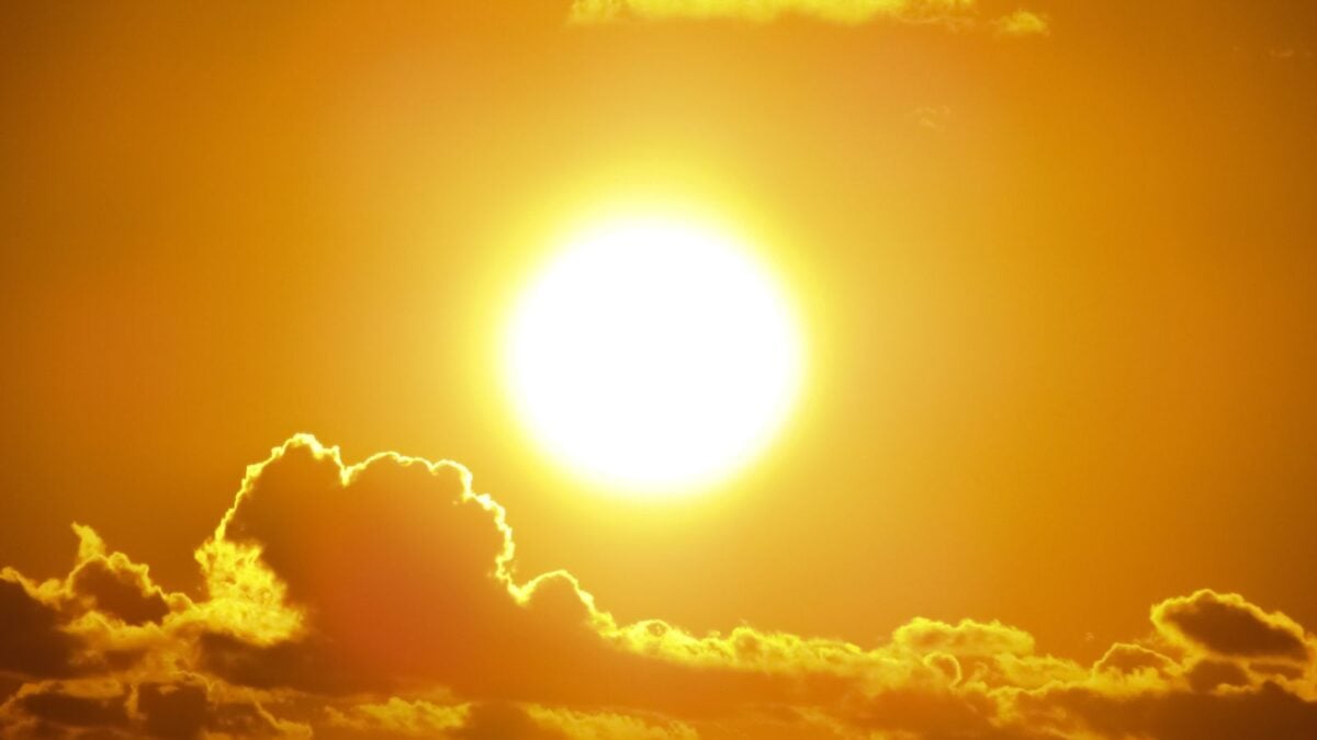A stunning view of the golden sun shining through clouds at sunset, casting a warm glow. A stunning view of the golden sun shining through clouds at sunset, casting a warm glow.