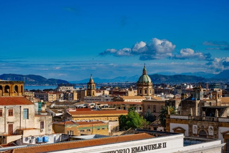 Discover the vibrant skyline of Palermo, Sicily capturing historic architecture beneath a bright blue sky.