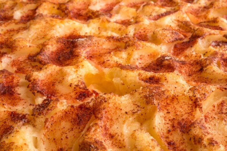 Delicious close-up of grilled mashed potato topping with golden brown crust and spices.