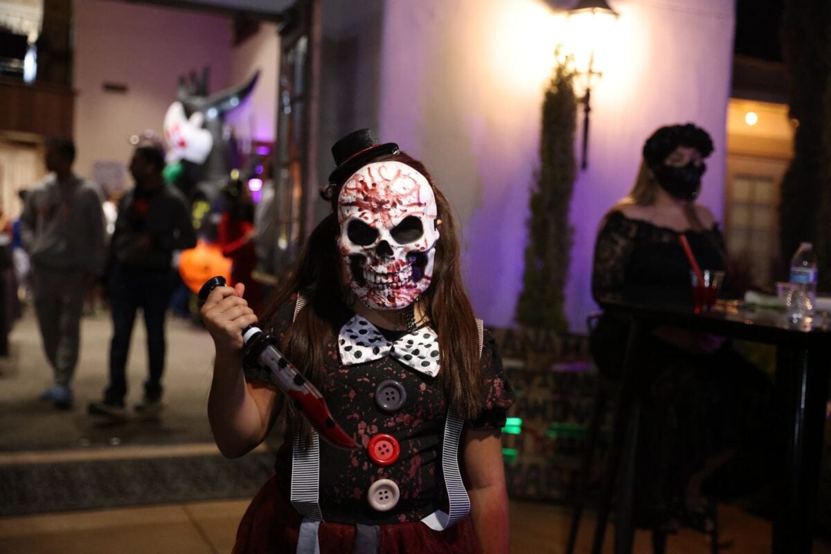 A child in a scary skull mask and costume at a Halloween party.