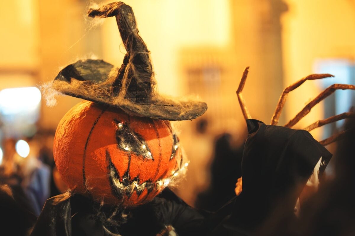 A spooky pumpkin head with a witch hat captured in a festive Halloween parade in Arequipa, Peru.