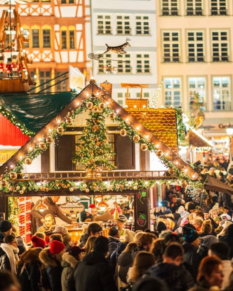 A bustling Christmas market filled with people and festive decorations in a vibrant setting.