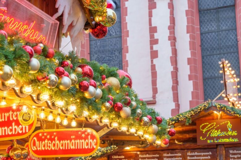 Vibrant Christmas market stall adorned with festive greenery and ornaments, creating a cozy holiday atmosphere.