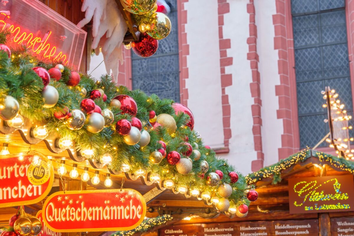 Vibrant Christmas market stall adorned with festive greenery and ornaments, creating a cozy holiday atmosphere.