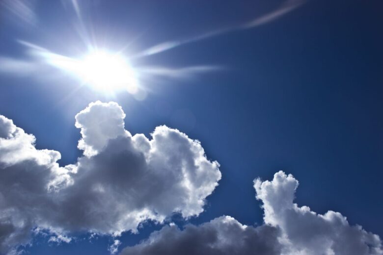 Bright sunny day with vivid blue sky and fluffy clouds.