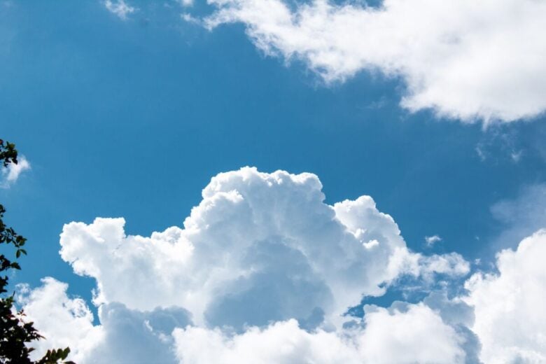 Cumulus clouds in a bright blue sky create a serene and airy atmosphere.