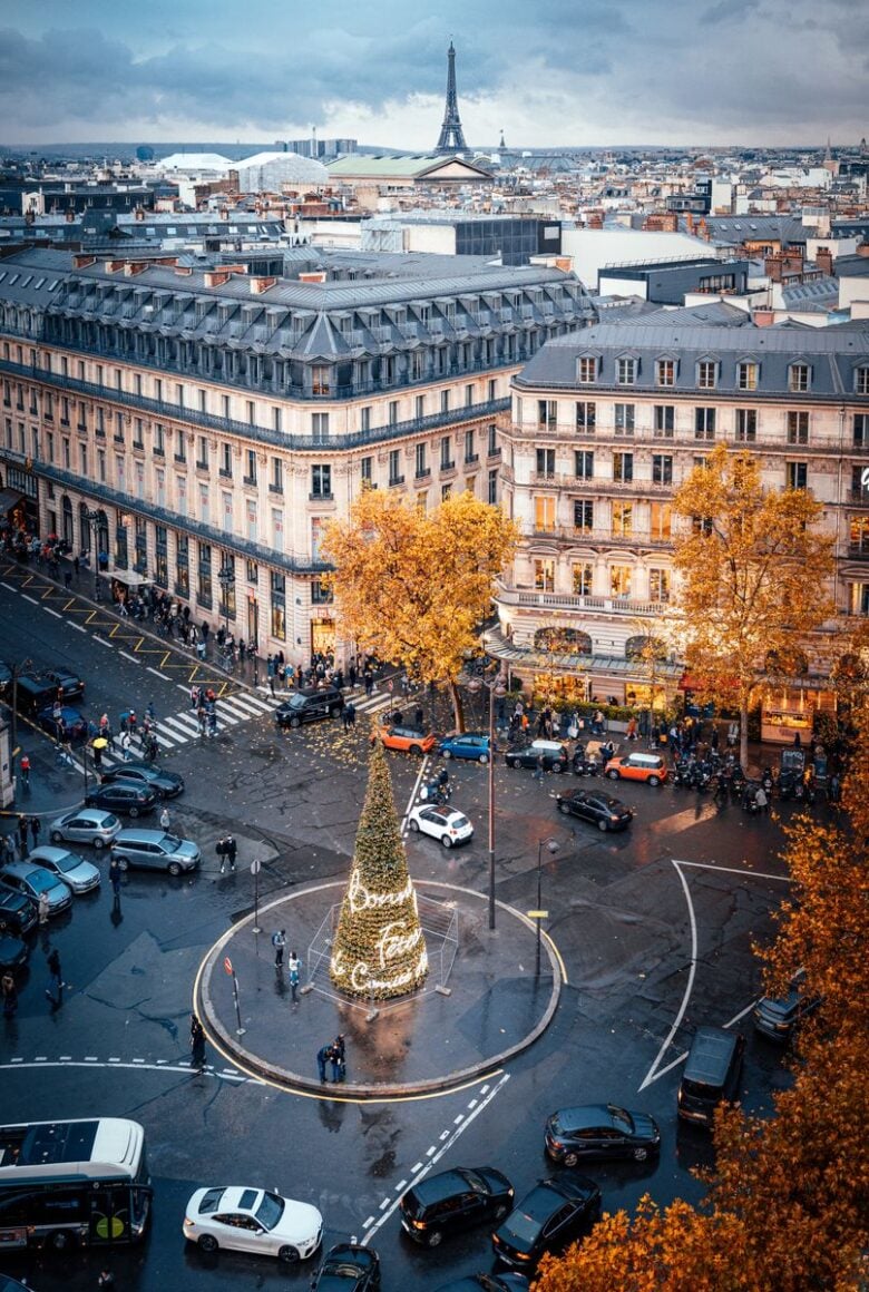 Stunning aerial view of Paris boulevard with Christmas tree and iconic Eiffel Tower in the background.