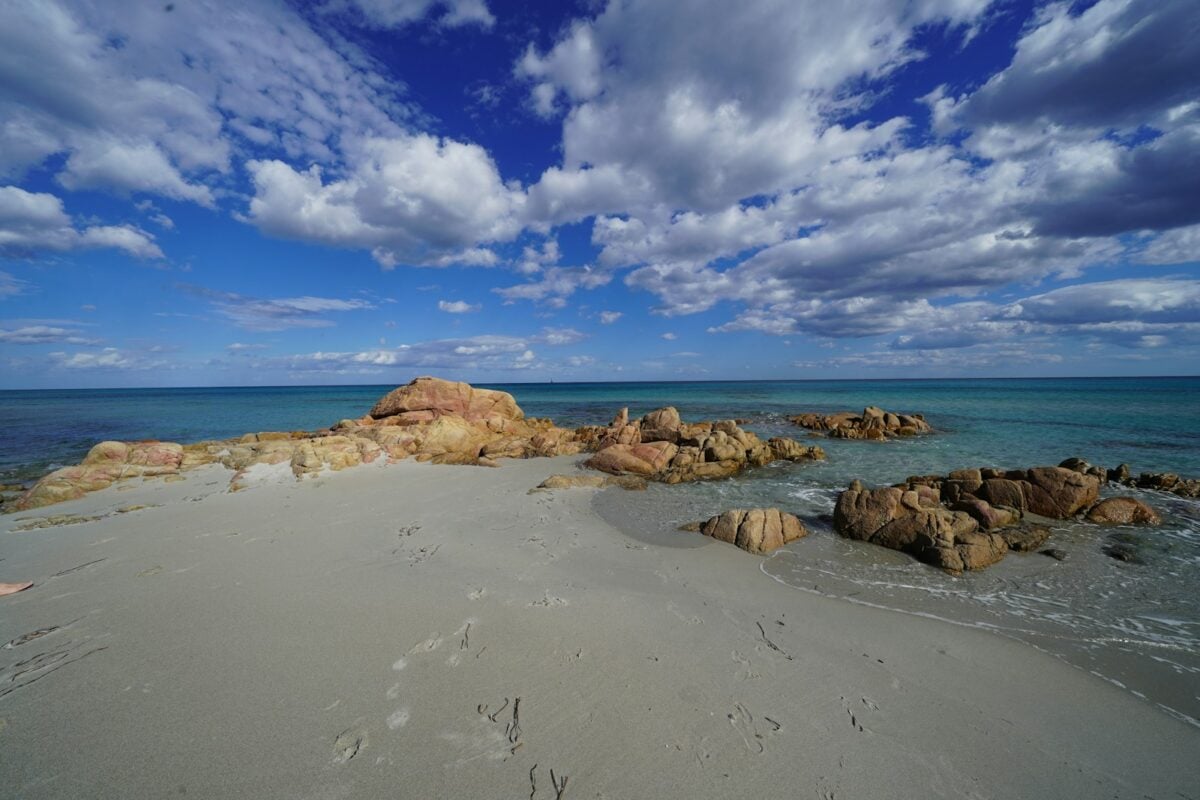 brown rocks on seashore under blue sky and white clouds during daytime