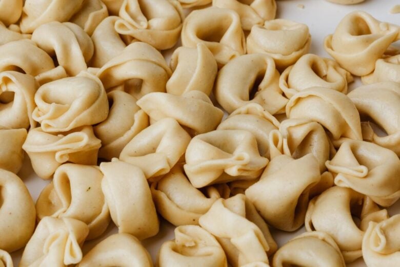 Detailed close-up view of a pile of uncooked homemade tortellini, showcasing Italian culinary tradition.