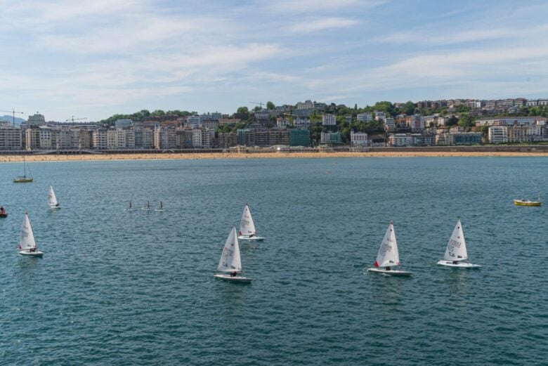 Sailboats on the scenic waters of San Sebastián Bay with the city in the background.